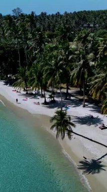 Koh Kood Tayland 'da ziyaretçilerin sallanan palmiye ağaçlarının altındaki beyaz kumda dinlendikleri tenha bir plajın güzelliğini keşfedin. Kristal gibi berrak sular ılık güneşin altında parlıyor..