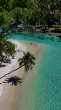 Parlak turkuaz sular Koh Kood Tayland 'da sakin bir sahilde yumuşak kumlu kıyılarla buluşur. Bereketli palmiye ağaçları ve yumuşak dalgalar rahatlama ve keşif için sakin bir ortam yaratır..