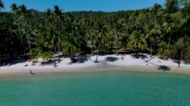 Turkuaz sular, bereketli palmiye ağaçları tarafından çerçevelenmiş beyaz kumlara nazikçe sarılır. Yumuşak bir esinti Koh Kood Tayland yapraklarını hışırdatırken güneşlenen güneşli atmosferde dinlenir.