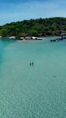 Koh Mak ve Koh Kham Adası 'nın sakin, turkuaz sularında iki kişi birlikte yürüyor. Bereketli yeşil manzaralar ve kayalık oluşumlar rahatlamak için mükemmel, pitoresk bir tropikal cennet yaratır..