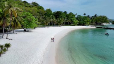 Tayland 'daki Koh Mak ve Koh Kham Adası' nın dingin güzelliğini görün. Beyaz kumlu plajlar ve canlı yeşillikler sıcak kıyı şeridi boyunca sakin yürüyüşler için mükemmel bir zemin oluşturur..