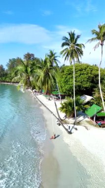 Tayland 'daki Koh Kood Adası' nın dingin güzelliğini keşfedin. Yumuşak dalgaların el değmemiş kumlara çarptığı yer. Bereketli palmiye ağaçları rüzgarda hafifçe sallanarak huzurlu bir kaçış yaratıyor..