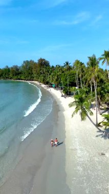 Altın kumlar ve turkuaz sular Koh Kood Adası Tayland 'da pitoresk bir zemin oluşturur. İki arkadaş kıyı boyunca parlak bir gökyüzünün altında doğa güzelliğine dalmış bir şekilde geziniyor. Rahatlamak için mükemmel..