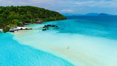 Yumuşak kumların kristal berrak turkuaz sularla buluştuğu Koh Kham Adası Tayland 'ın nefes kesici güzelliğini keşfedin. Bu tropikal cennet, açık bir gökyüzü altında rahatlamaya ve maceraya davet ediyor..