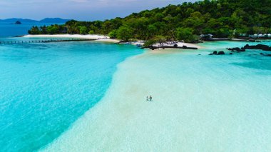 Turkuaz sular, Koh Kham Adası 'nın yumuşak kumlu kıyılarına nazikçe sarılarak ziyaretçileri Tayland' da güneşli maceraların tadını çıkarmaya davet ediyor.