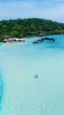 Kendinizi Tayland 'daki Koh Kham Adası' nın huzurlu güzelliğine bırakın. Yumuşak beyaz kumlar berrak turkuaz sulara karışıyor, bu tropikal cennette rahatlama ve macera arayan ziyaretçileri cezbediyor..