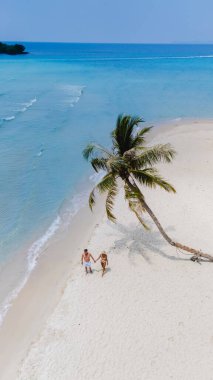 Turkuaz sular ve sallanan palmiyelerle çevrili Koh Kood Adası 'nın büyüleyici kumlu sahillerinde el ele dolaşarak mükemmel bir tropikal cennet yaratıyor.