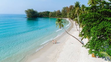 Ziyaretçiler Tayland 'daki Koh Kood Adası' nın sakin beyaz kumlu plajlarının tadını çıkarıyorlar. Kristal berrak sular ve yüksek palmiye ağaçları plaj aşıkları için bir cennet yaratır..