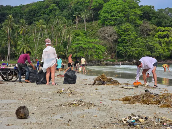 Koh Kood, Tayland, 13 Mart 2025. Gönüllüler kumlu plaj boyunca toplanarak çöpleri, çöpleri ve plastikleri temizlemeye çalışıyorlar.