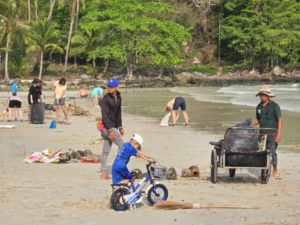 Koh Kood, Tayland, 13 Mart 2025, Topluluk üyeleri plajı temizlemek ve çevre bilincini artırmak için toplandılar. Fırtınadan sonra plajı temizleyen bir turist.