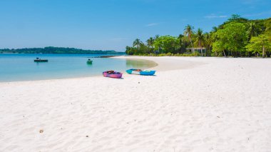 Yumuşak beyaz kum Koh Kham Adası Tayland 'da durgun turkuaz sularla buluşur. Kürek çeken kayıklar, ziyaretçileri Koh Kham 'ın güzelliğini keşfetmeye davet ediyor. Cennette mükemmel bir günün tadını çıkar..
