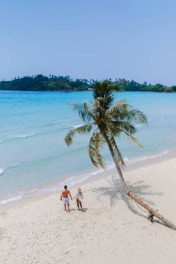 Bir çift, Tayland 'daki Koh Kood Adası' nın güzel kumsalında el ele yürür. Turkuaz sular kıyıda tur atar ve palmiye ağaçları sallanır. Romantik bir atmosfer yaratır.