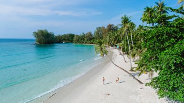 Tayland 'daki Koh Kood Adası' nda yumuşak beyaz kumlar kristal berraklığında sularla buluşur. Ziyaretçiler, bereketli palmiye ağaçları ve sakin bir atmosferle çevrili güneşlenme ve boş zamanlarında eğlenirler.