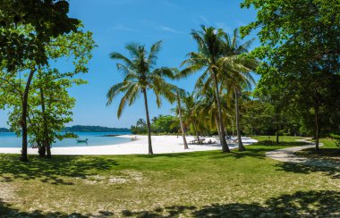 Tayland 'ın Koh Kham Adası' ndaki el değmemiş kumsalın huzurunun tadını çıkarın. Uzun palmiye ağaçları yumuşak beyaz kumları ve berrak turkuaz suları çerçeveler, rahatlama ve keşifleri teşvik eder..