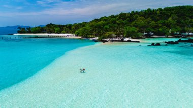 Koh Kham Adası Tayland 'ın büyüleyici turkuaz suları ve kumlu plajlarıyla güzelliğini keşfedin. Sakin, yemyeşil ve berrak mavi gökyüzünün altında canlı deniz yaşamının tadını çıkar..