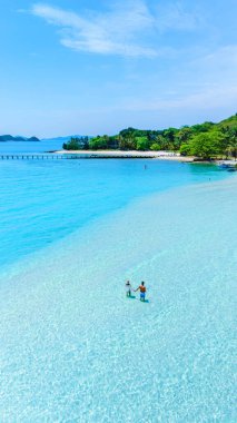 Tayland 'daki Koh Kham Adası' nın berrak sularını ve sakin plajlarını keşfedin. Ziyaretçiler parlak güneş ışığı altında bu cennet adasında yüzmeyi ve dinlenmeyi severler..