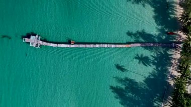 Koh Kood Tayland 'ın berrak sularına uzanan, sallanan palmiye ağaçları ve canlı doğayla çevrili tenha bir rıhtımın sakinliğini hissedin.. 