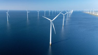 Kuzey Denizi 'nde dik duran açık deniz rüzgar türbinlerinin geniş görüşü yenilenebilir enerjiden faydalanıyor. Açık denizlerdeki yel değirmeni türbinleri Hollanda 'daki yeşil enerji geçişinde