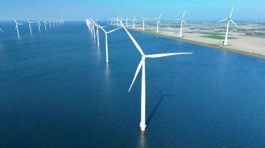 Denizaşırı rüzgar türbinleri Kuzey Denizi 'nin sakin suları üzerinde zarifçe dönerek Hollanda' daki enerjiyi yakalar. Offshore yel değirmeni türbinleri okyanusta yeşil enerji geçişinde 
