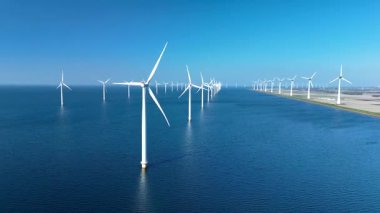Hollanda yakınlarındaki Kuzey Denizi 'ndeki bir açık deniz rüzgâr çiftliğinin çarpıcı hava manzarası. Şiddetli rüzgar türbinleri açık güneşli günlerde rüzgar enerjisinden faydalanıyorlar. Çevre dostu güç çözümlerini teşvik ediyorlar..