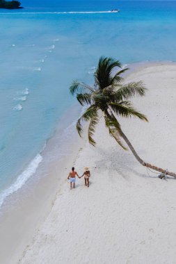 Sevgi dolu bir çift, Tayland 'daki Koh Kood Adası' nın güzel beyaz kumlarında el ele dolaşır. Huzurlu, kristal berraklığında turkuaz sularla çevrili, cenneti simgeler.