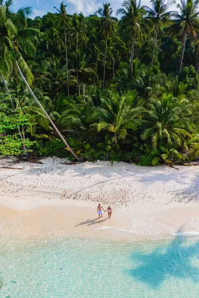 Tayland, Koh Kood Adası 'ndaki sakin bir sahil sahnesinde çiftler, sallanan palmiye ağaçları ve kristal berrak sudan oluşan, romantizm ve rahatlama için mükemmel bir tropikal cennetin keyfini çıkarırlar.