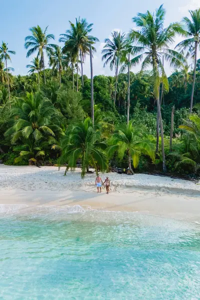 Koh Kood Adası, Tayland 'da nefes kesici, muhteşem bir sahil manzarası çevrenizdeki gür, sallanan palmiye ağaçlarıyla birlikte berrak suların nefes kesici güzelliğini sergiliyor.