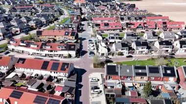 Güneş panelleri olan modern aile evleri ile dolu canlı bir Hollanda banliyö bölgesini keşfedin. Bu yeni geliştirilmiş konut kompleksinde rahat yaşamanın özünü keşfedin..