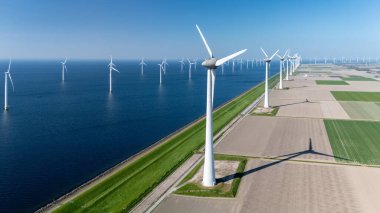 Serin mavi bir okyanusa karşı kurulmuş sayısız rüzgar türbininin yer aldığı geniş bir açık deniz rüzgâr çiftliği. Açık denizlerdeki yel değirmeni türbinleri Hollanda 'daki yeşil enerji geçişinde