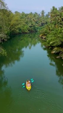 Tayland 'ın sakin nehirlerinde kürek çeken çiftler yemyeşil ortamda macera dolu bir günün tadını çıkarıyorlar. Sakin sular bu huzurlu ortamda doğanın güzelliğini yansıtıyor..