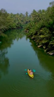 Tayland 'ın sakin nehirleri boyunca canlı yeşilliklerle çevrili kürek çekin. Doğanın ahengine tanık olun. Kanocular pürüzsüz bir şekilde süzülüyor, nefes kesici manzarada ve huzurlu atmosferde sırılsıklam oluyorlar..