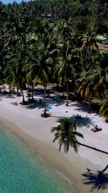 Koh Kood Tayland 'daki çarpıcı plajın sakinliğini içine çek. Yumuşak kumlar ziyaretçileri sallanan palmiye ağaçlarının altında dinlenmeye ve güneşli bir günde canlı turkuaz suların tadını çıkarmaya davet eder..