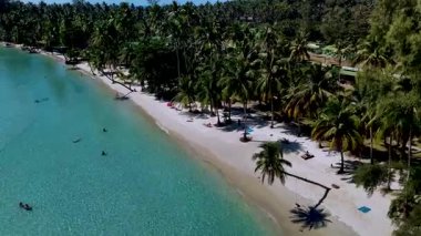 Koh Kood Tayland 'da el değmemiş bir plajın huzur dolu güzelliğini hissedin. Yumuşak dalgaların kumlu bir kıyıya vurduğu ve palmiye ağaçlarının ılık esintide sallandığı yerde..
