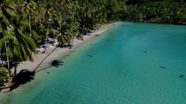 Koh Kood Tayland 'da turkuaz dalgaların yumuşak kuma çarptığı sakin bir plajı keşfedin. Palmiye ağaçları ılık rüzgarda hafifçe sallanarak rahatlamak ve eğlenmek için mükemmel bir kaçış sağlar..