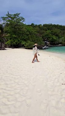 Tayland 'daki Koh Kham Adası' nın el değmemiş beyaz kumlarında sakin bir yürüyüş. Yeşillik ve berrak sularla çevrili bu yer rahatlama ve keşif için mükemmel bir kaçış sağlar..