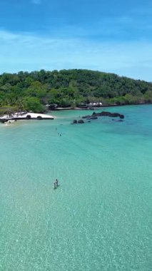 Koh Kham Adası Tayland büyüleyici turkuvaz suları ve yemyeşil sularla çevrili el değmemiş plajlar sunar. Ziyaretçiler yüzmekten, güneşlenmekten ve huzurlu manzaraları keşfetmekten zevk alabilirler..
