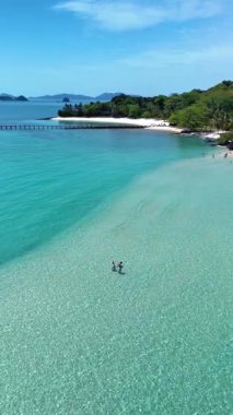 İki birey, Koh Kham Adası 'nın el değmemiş kıyı şeridi boyunca huzurlu bir gezintinin tadını çıkarıyor. Sakin turkuaz sular ve yemyeşil yemyeşil Tayland 'da sakin bir tropik kaçış yaratır.