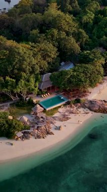 Tayland 'ın el değmemiş kıyılarına kurulmuş bu verimli tropikal tatil beldesinde canlı yeşilliklerle çevrili parlak bir havuz bulunur. Misafirler sükunetin ve nefes kesici okyanus manzarasının tadını çıkarıyorlar..
