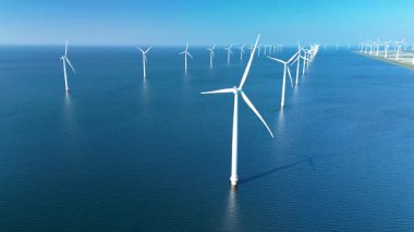 Hollanda 'daki uçsuz bucaksız bir yel değirmeni parkının nefes kesici görüntüsü. Hollanda' daki okyanus yeşili enerji geçişinde sayısız uzun türbin ve Offshore yel değirmeni türbinleri bulunuyor.