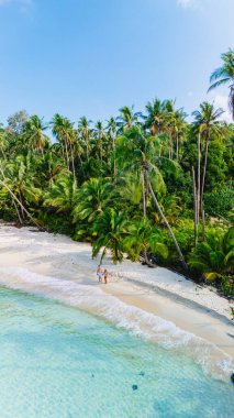 Tayland 'daki güzel Koh Kood Adası' nda serinletici zümrüt suları ve rüzgarda hafifçe sallanan gür palmiye ağaçlarını gösteren sakin bir plaj hayal edin.