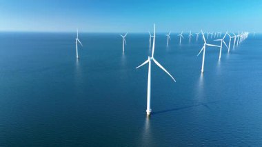 Yel değirmenleri Kuzey Denizi 'nin sakin sularında zarifçe dönerek sürdürülebilirliği desteklemek için rüzgar enerjisini kullanıyorlar. Açık denizlerdeki yel değirmeni türbinleri Hollanda 'daki yeşil enerji geçişinde