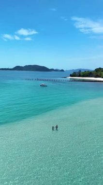 Tayland 'daki Koh Kham Adası' nın nefes kesici manzarasını deneyin. Kristal suların kumlu kıyılarla buluştuğu yer. Ziyaretçiler açık mavi gökyüzü altında dinlenme ve keşif günlerinin tadını çıkarıyorlar..