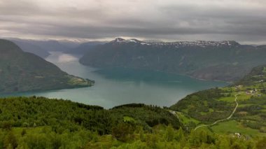 Molden Norveç 'in göbeğine yerleşen bu nefes kesici manzara, bereketli tepeler ve karla kaplı dağlarla çevrili sakin bir fiyort yakalar. Bulutlar havada süzülüyor, büyüleyici bir atmosfer yaratıyor..