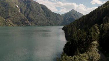 Norveç fiyortlarının nefes kesici güzelliğini keşfedin. Zümrüt dağları sakin sulardan keskin bir şekilde yükselir ve huzurlu bir kaçış yaratır. Doğanın ihtişamı her yöne doğru yayılır..