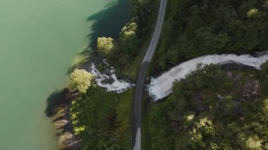 Şelale gibi akan bir nehrin serin bir su kütlesine dönüşmesi nefes kesici bir manzara. Bereketli yeşillik kıyıları kucaklarken dolambaçlı bir yol Norveç 'te serüven manzarayı davet ediyor..
