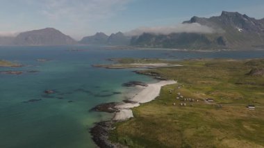 Lofoten Norveç kıyılarının nefes kesici manzarası turkuaz bir denizin üzerinde yükselen büyüleyici dağları gözler önüne seriyor..