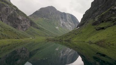 Norveç 'in sakin vadisinde yemyeşil yemyeşil sularla çevrili berrak sulardaki görkemli dağların çarpıcı yansımasına hayret ediyorum. Doğaya mükemmel bir kaçış..