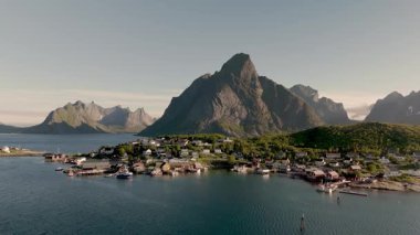 Fiyortlarla çevrili, yüksek dağlarla çevrili büyüleyici bir köyün nefes kesici manzarası. Güneş, Norveç 'in doğal güzelliğini artırmak için sıcak bir parıltı yayar. Reine Lofoten 