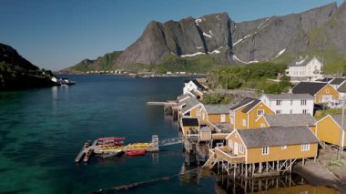Norveç 'teki bir sahil köyünün sakin suları boyunca ayaklıklar üzerine inşa edilmiş büyüleyici evler. Sakrisoy, Moskenes, Lofoten adaları. Norveç.