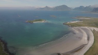 Lofoten Norveç kıyılarının nefes kesici manzarası, sakin bir körfez ve yuvarlanan tepeler.